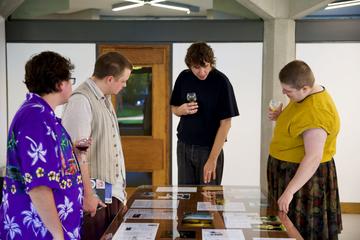 People at exhibition People looking at documents in an exhibition display cabinet