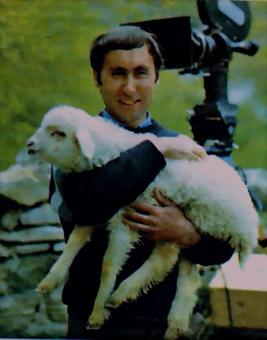 Goderzi Choxeli standing outside holding a lamb