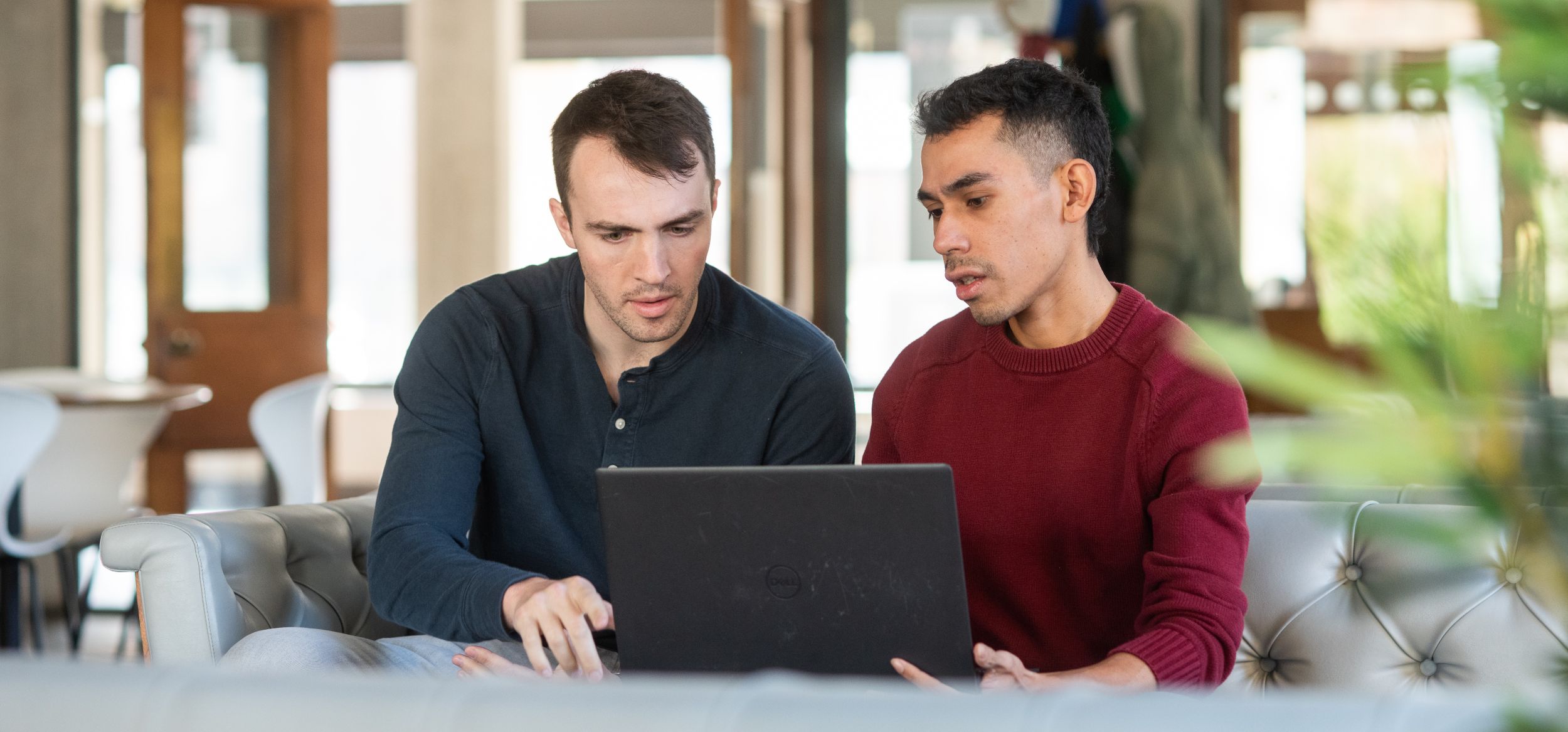 Two students looking at a laptop 