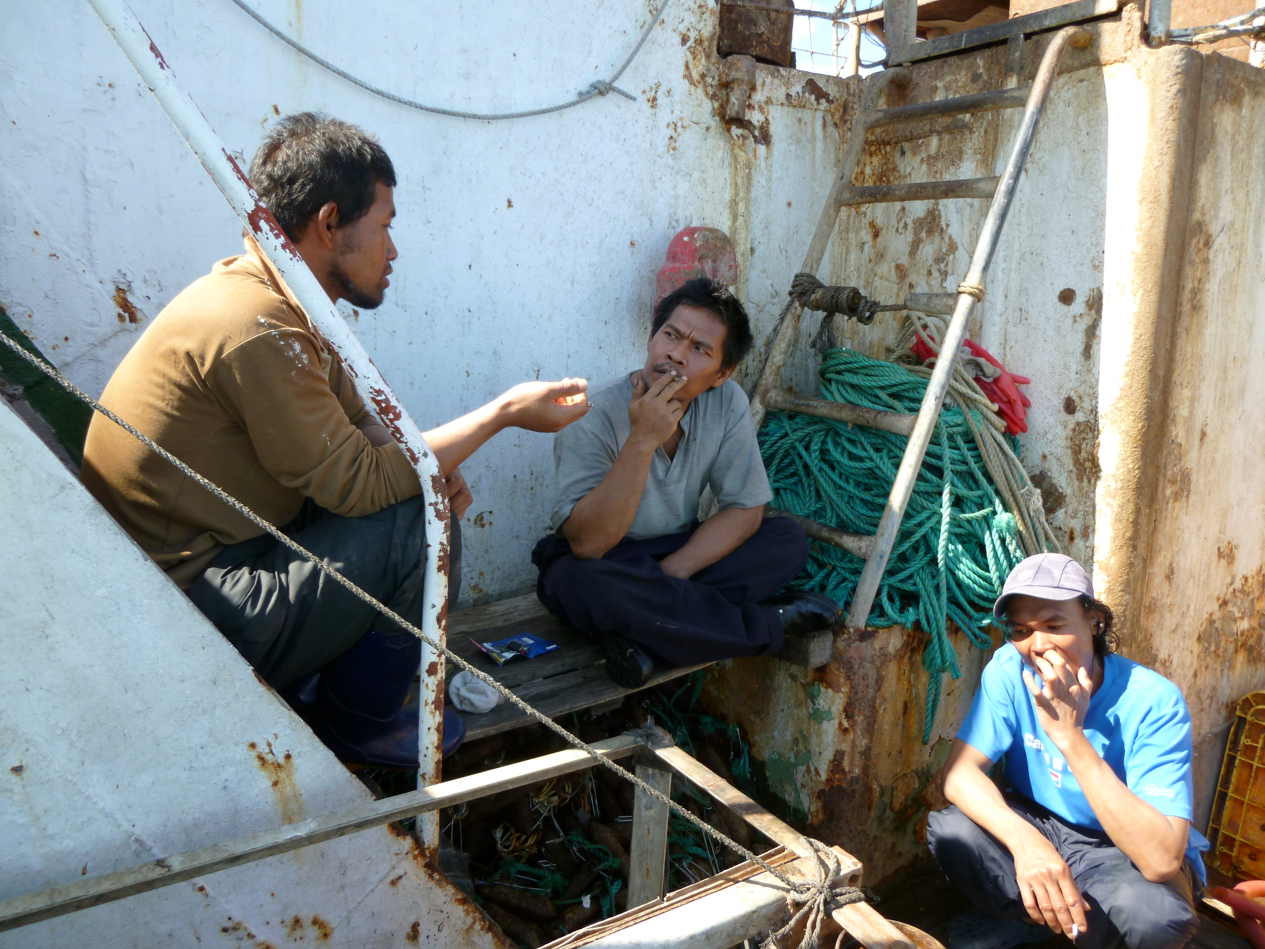 Workers sat smoking on a fishing boat