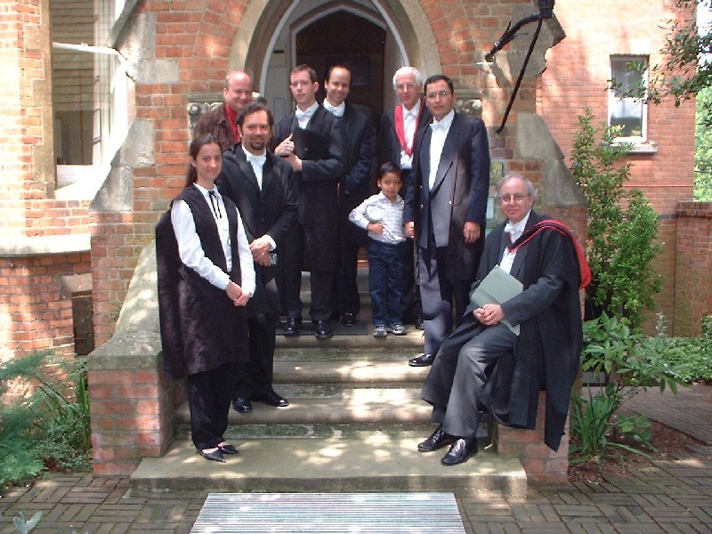 Students in academic dress, standing on steps outside a building with A Angell and M Deas