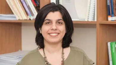 Dr Lobzhanidze has dark-shoulder length hair and is wearing a light green top with a beaded necklace