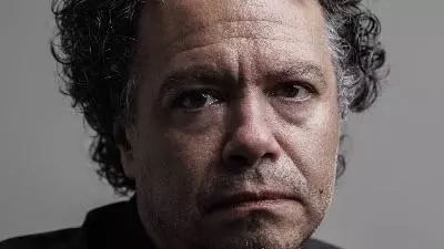 Oswaldo E. do Amaral has short curly dark hair. He is looking directly into the camera with his face partially in shadow