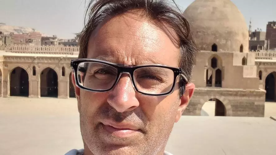 Jorge Luengo has short dark hair and glasses. 
