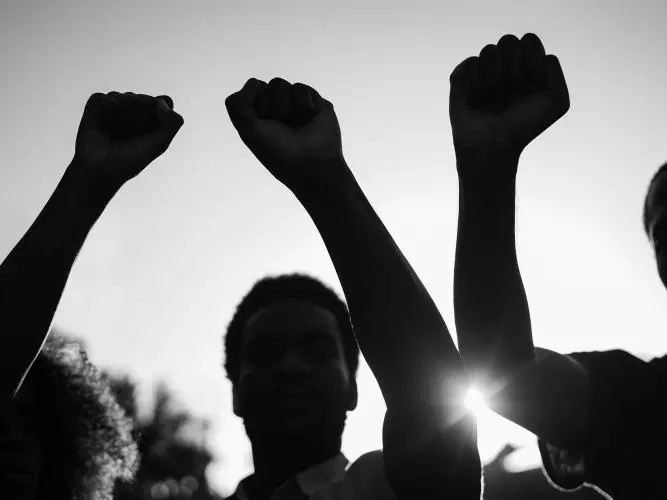 Three people with fists raised 