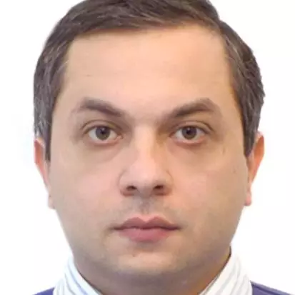 Dr Kobakhidze has short brown hair. He is wearing a shirt and blue jumper