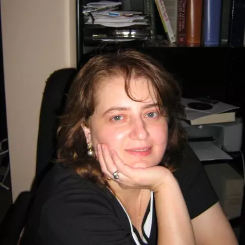 Nino Kavtaria has short brunette hair. She is wearing black top and leaning forward, resting her chin on her hand