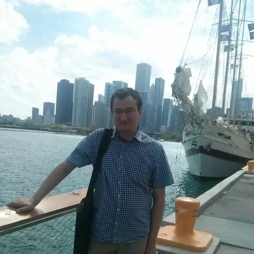 Shota Matitashvili is standing on a boat, leaning against the handrail with a city skyline in the background