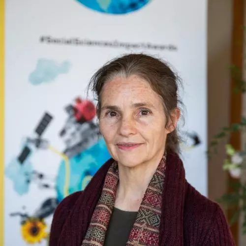 Sabina Alkire wearing a burgundy jacket and a red, brown and camel scarf