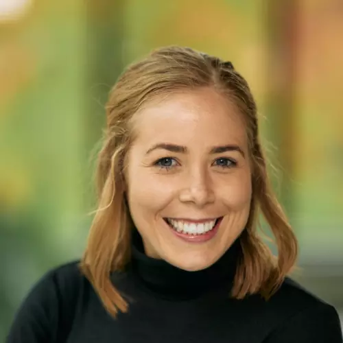 Dr Marnie Howlett has shoulder length blonde hair and is smiling broadly at the camera. She's wearing a black jumper.