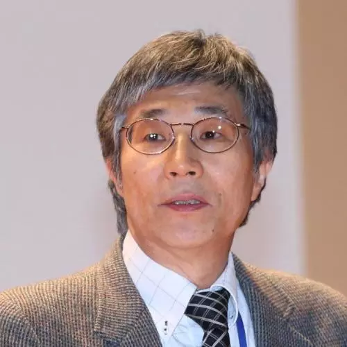 takehiko kariya has short grey hair, wearing glasses, and dressed in a white shirt, black and white striped tie, and brown woollen jacket